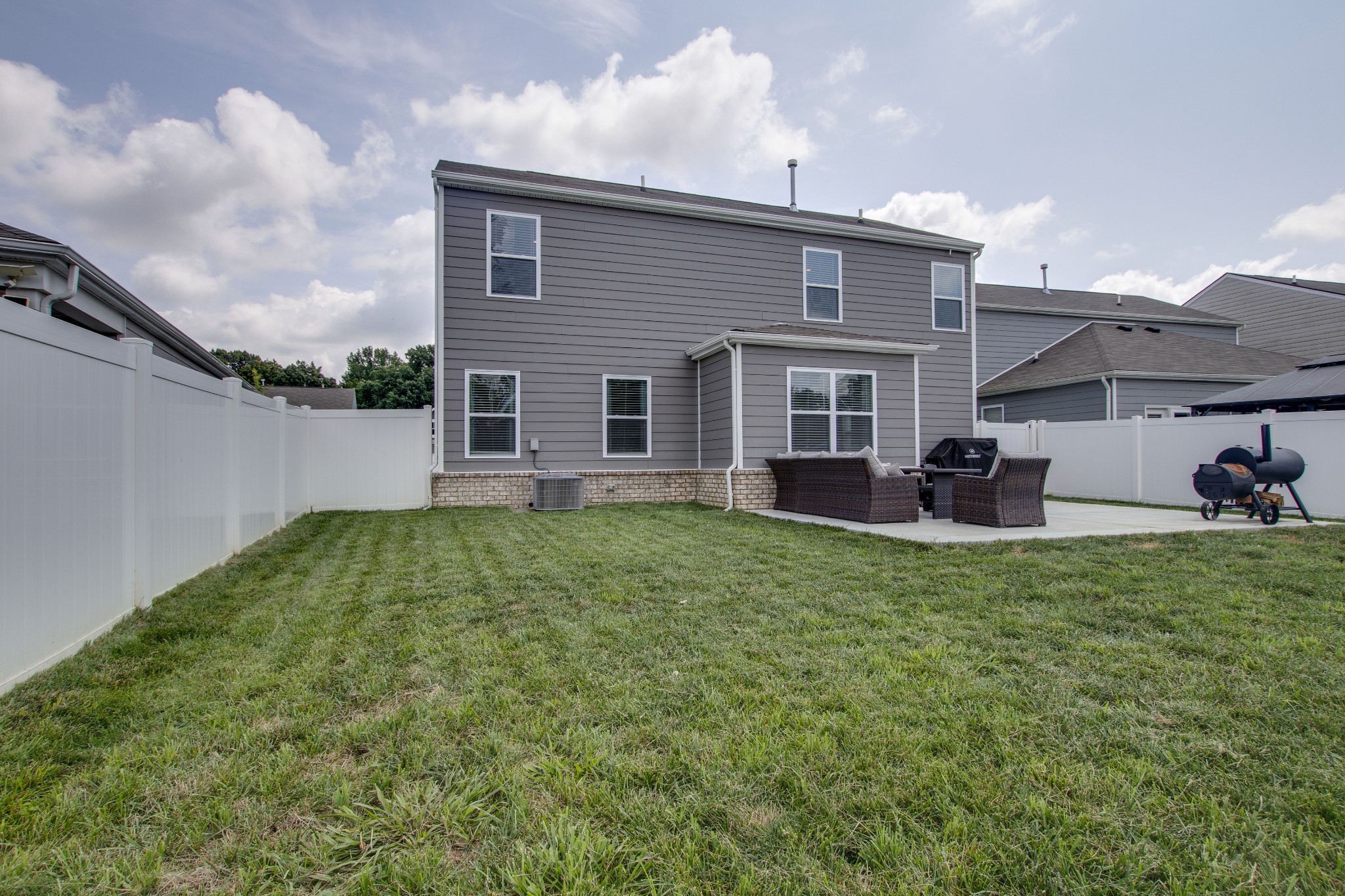 Fenced backyard with extended patio and swing set